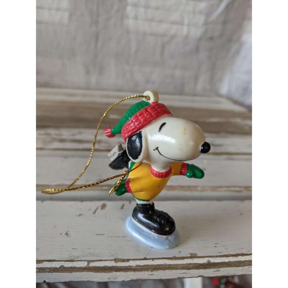 United feature Snoopy skating green hat ornament X